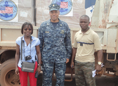 Dr. Nadine Ndonghan Iyangui of the Université Omar Bongo’s Mapping and Graphics Library (Laboratoire de Graphique et de Cartographie) and LCDR Cornell Sinclair (center) of the US Navy Maritime Partnership Program are ready to distribute books.