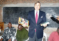 U.S. Ambassador to Rwanda Stuart Symington hands out books to students at Groupe Scolaire Mukamira in Nyabihu district, Northern Province.