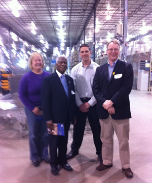 At the Follett warehouse. From left: Juli Hubbard, Vice President Administration and Operations at Follett; Mr. Alexander Gbayee, Consul General of Liberia; Joe Miller, Vice President Facility and Finance at Follett; and Patrick Plonski, Executive Director of Books For Africa.
