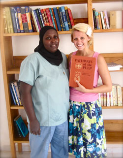 Fatu, the head dental nurse, and Megan Meyer, director of A Hand in Health, show off dental books collected from the University of Minnesota School of Dentistry.