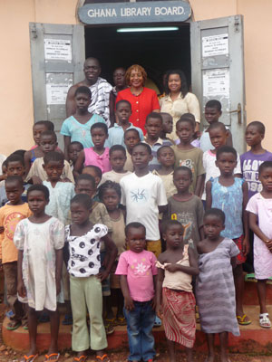 From left: Fibbens Koranteng, NBA member and native of Abiriw Village; NBA President Mavis T. Thompson; and NBA board member Ronda F. Williams with children on steps of Abiriw Village Library.