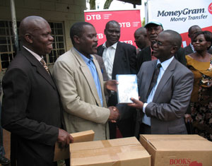 Dr. Robert Masese (center), Director of Secondary and Tertiary Education in Kenya, presents BFA books at the distribution ceremony.