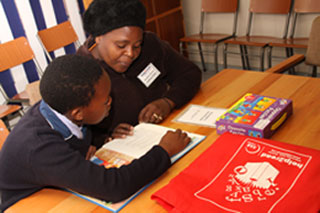 A reading helper from help2read shares her love of reading with a student in Cape Town, South Africa.