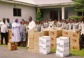 Students and faculty at Saint Martin De Porres Girls' College in Nigeria pose with boxes of BFA books from the container they recently received.