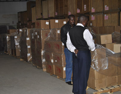 Taic Mwanza, warehouse coordinator for Room to Read, left, and Barniston Laimo, librarian for the Zambia Bar Association, with the 20,000+ books donated by Thomson Reuters and Books For Africa.