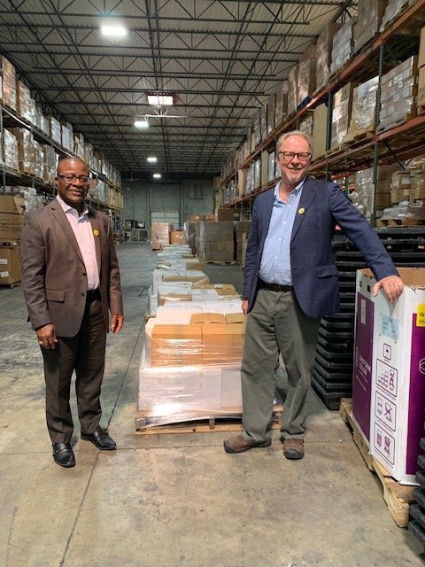 BFA Board President Mike Essien (left) and Executive Director Patrick Plonski with a Law & Democracy Library in BFA's Georgia Warehouse
